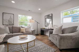 Living room with plenty of natural light, wood finished floors, recessed lighting, and baseboards