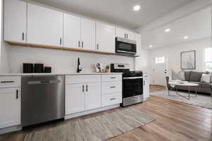 Kitchen featuring stainless steel appliances, recessed lighting, a sink, light wood finished floors, and light countertops