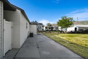View of home's exterior featuring a patio, a yard, and central AC