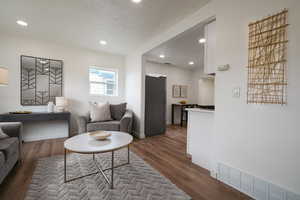 Living room featuring dark wood-style floors, recessed lighting, and a textured ceiling
