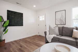 Living room with wood finished floors, baseboards, and recessed lighting