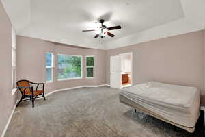 Carpeted bedroom with baseboards, ensuite bath, and ceiling fan