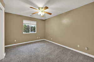 Carpeted empty room with baseboards and ceiling fan