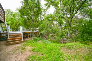 View of yard featuring a wooden deck and stairs