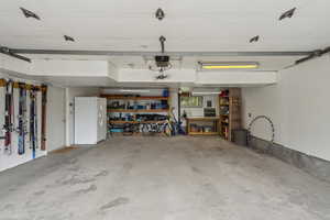 Garage featuring white fridge with ice dispenser and a garage door opener