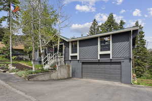 View of front of property featuring an attached garage and asphalt driveway