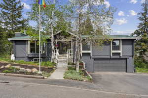 View of front of home featuring asphalt driveway and an attached garage