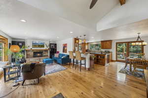 Living area with light wood finished floors, a fireplace, recessed lighting, lofted ceiling, and ceiling fan