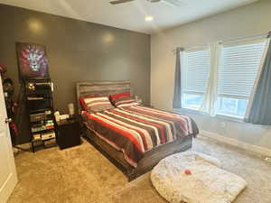 Carpeted bedroom featuring baseboards and a ceiling fan