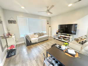 Living area featuring a ceiling fan, wood finished floors, baseboards, and recessed lighting