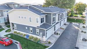 View of side of home featuring roof with shingles, central AC, an attached garage, and a lawn