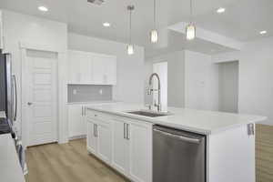 Kitchen featuring appliances with stainless steel finishes, a sink, light wood-type flooring, white cabinetry, and recessed lighting