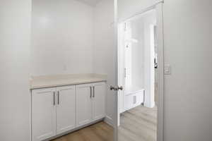 Hall featuring light wood-style flooring and baseboards