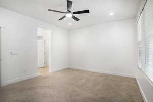 Spare room featuring light colored carpet, ceiling fan, baseboards, and recessed lighting