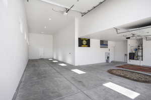 Garage featuring a garage door opener and water heater