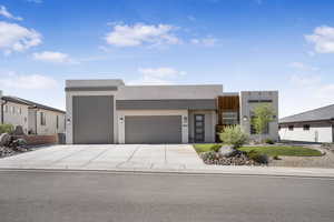Modern home with an attached garage, driveway, and stucco siding