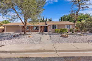 Ranch-style home featuring an attached garage and driveway