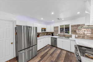 Kitchen with stainless steel appliances, a sink, white cabinetry, and recessed lighting