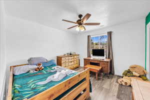 Bedroom with light wood-style flooring and a ceiling fan
