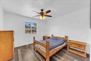 Bedroom featuring wood finished floors, baseboards, and a ceiling fan