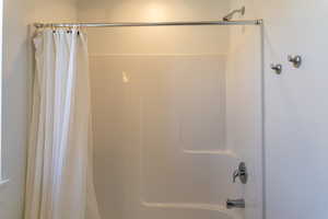 Full bathroom featuring shower / bathtub combination with curtain