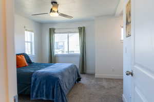 Carpeted bedroom featuring baseboards and ceiling fan