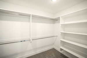 Walk in closet with dark colored carpet
