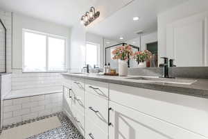 Bathroom featuring a stall shower, double vanity, tile patterned flooring, tiled bath, and recessed lighting