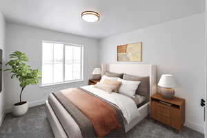 Bedroom featuring dark carpet and baseboards