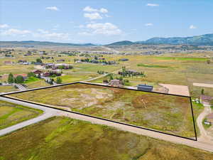 Aerial view of property and surrounding area with mountains and property parcel outlined
