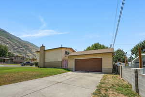 View of side of property with a detached garage and a mountain view