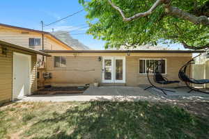 Back of house with a patio area, brick siding, and a lawn