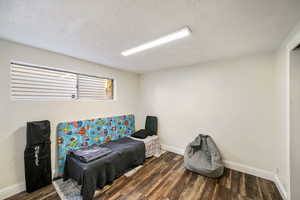 Bedroom featuring wood finished floors and a textured ceiling