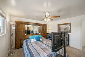 Carpeted bedroom featuring baseboards and ceiling fan