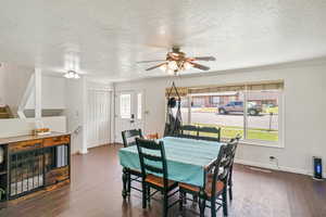 Dining room featuring wood finished floors, ceiling fan, a textured ceiling, and crown molding