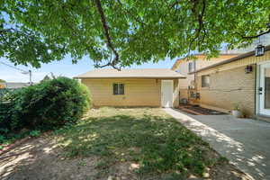 Rear view of house featuring a yard and a patio