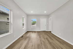 Unfurnished room featuring wood finished floors, baseboards, and recessed lighting