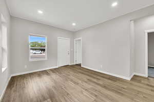 Unfurnished room with wood finished floors, baseboards, and recessed lighting