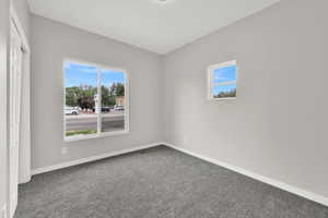 Empty room featuring carpet and baseboards