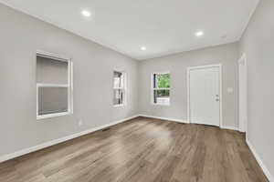 Empty room with wood finished floors, baseboards, and recessed lighting