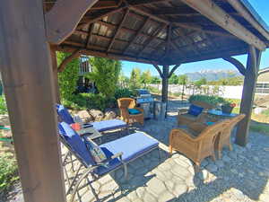 View of patio / terrace with a gazebo, a mountain view, fence.