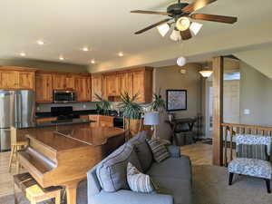 Living area featuring light wood-style floors, ceiling fan, and recessed lighting