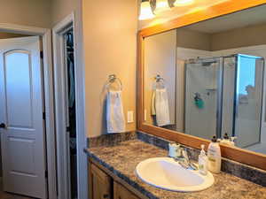 Master bathroom featuring a stall shower, vanity, and a walk-in closet