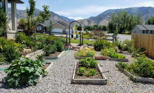View of yard featuring a garden, a mountain view, and fence
