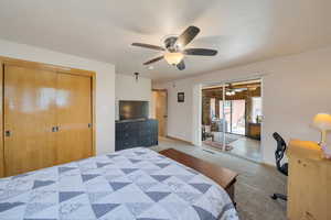 Carpeted bedroom with baseboards, a ceiling fan, and a closet