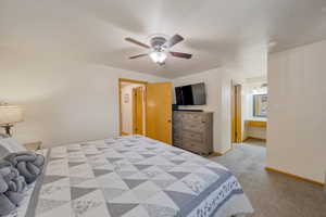 Bedroom with light carpet, baseboards, and a ceiling fan
