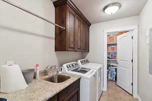 Clothes washing area featuring independent washer and dryer, cabinet space, and a textured ceiling
