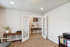 Carpeted office space featuring french doors, baseboards, and recessed lighting