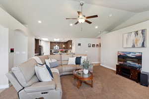 Carpeted living area with recessed lighting, a ceiling fan, baseboards, and lofted ceiling
