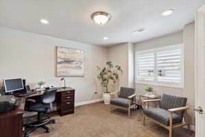 Office space featuring light colored carpet, baseboards, and recessed lighting